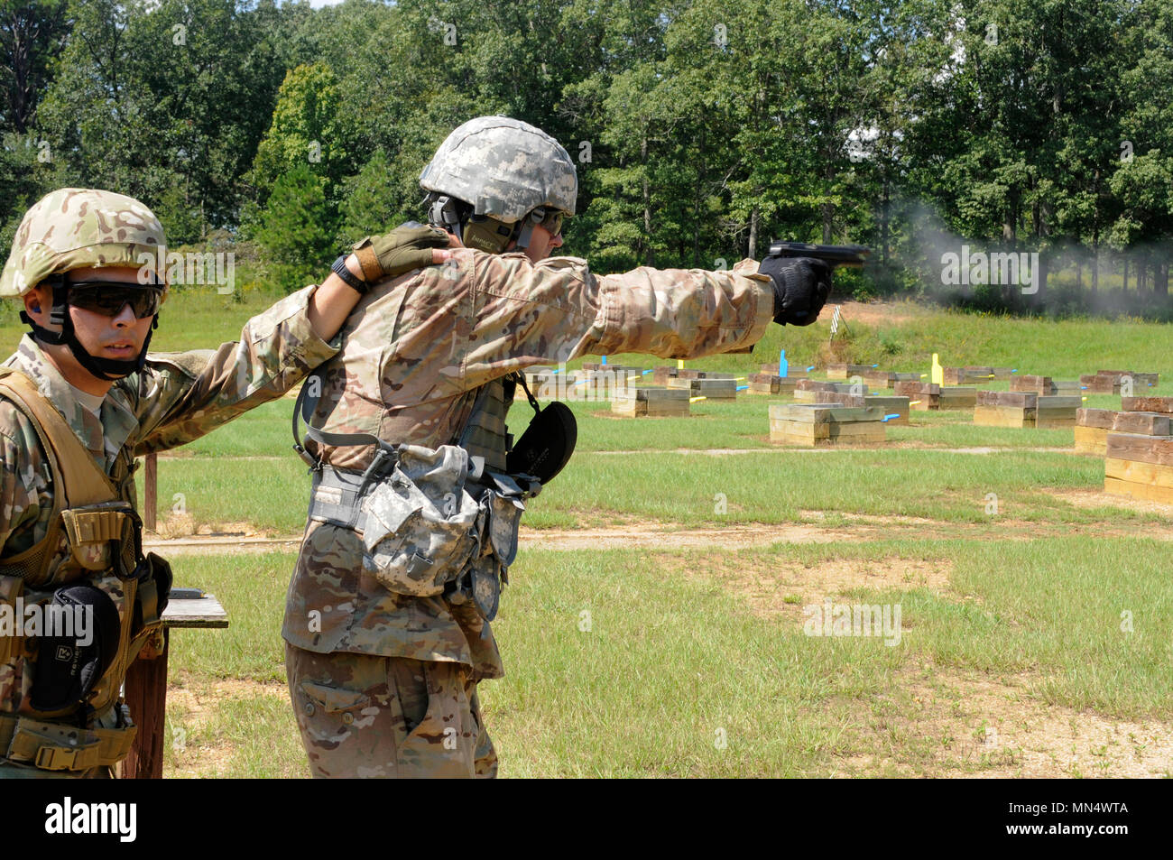 Us-Armee Pvt. Joshua A. Tag von Dallas, Ga, mit der 642 . Regionale Unterstützung Gruppe feuert seine Pistole auf Treffsicherheit Training 12.08.20 Während eine Combat Training übung am Fort McClellan, Ala 2 Lt Armano Rodriguez von Buford, Ga, die Force Protection Officer, dient als Sicherheit. Die Armee finden in Decatur, Ga (USA. Armee Foto von Sgt. 1. Klasse Gary A. Witte) Stockfoto