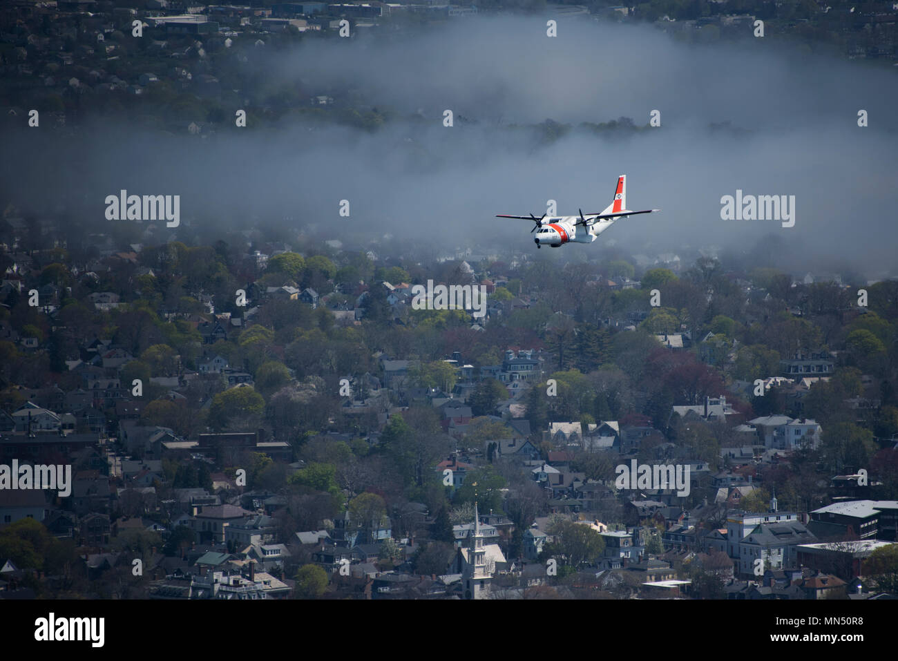 Die HC-144 Ocean Sentry ist ein von der United States Coast Guard betriebenes mittleres Überwachungsflugzeug. Der Archivdruck dokumentiert den Flug über Newport, Rhode Island, am 8. Mai 2018 im Rahmen der Eröffnung des Volvo Ocean Race Village. Der Druck zeigt typische Merkmale der Luftfotografie der Küstenwache. Stockfoto