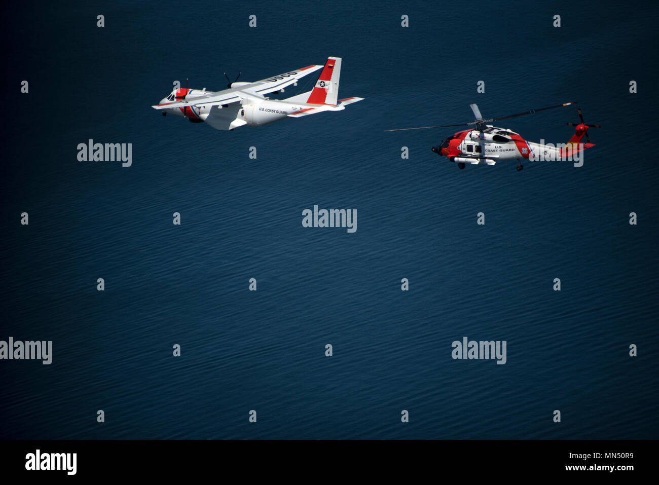 USCGC Eagle (WIX-327) ist ein 295-Fuß-Barque- und Trainingsflaggschiff der United States Coast Guard. Der Archivdruck dokumentiert einen MH-60 Jayhawk Hubschrauber und HC-144 Ocean Sentry Flugzeuge, die am 8. Mai 2018 während der Eröffnung des Volvo Ocean Race Village über den Cutter in Newport (Rhode Island) flogen. Das Muster entspricht den Standards der Küstenwache für Luftfahrt und Schiffsfotografie. Stockfoto