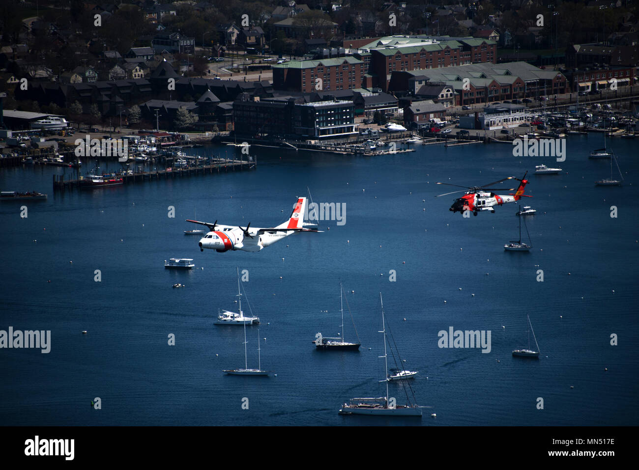 Die United States Coast Guard Air Station Cape Cod betreibt HC-144 Ocean Sentry Marine Patrouillenflugzeuge und MH-60 Jayhawk Helikopter für Such- und Rettungsaktionen und maritime Sicherheit. Die Flugzeuge führen am 8. Mai 2018 einen Überflug über Newport, Rhode Island durch, während der Eröffnung des Volvo Ocean Race Village und des Überflugs des USCGC Eagle. Das Archivbild dokumentiert die feierliche Unterstützung der Luftfahrt und die Anerkennung des maritimen Erbes. Stockfoto