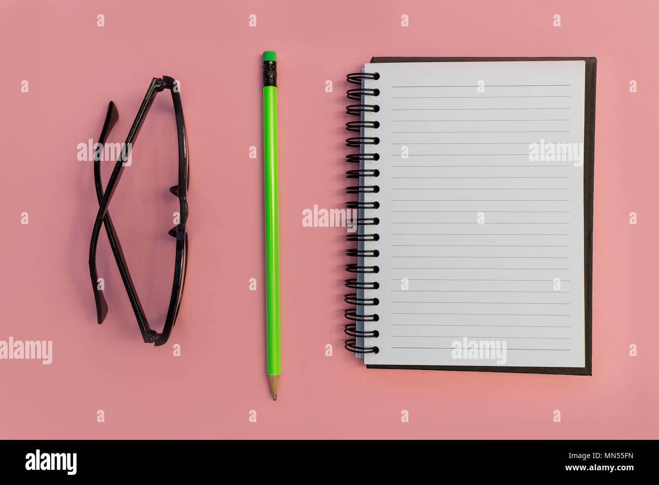 Bildung notebook Bleistift und Brillen auf hell rosa Hintergrund Stockfoto