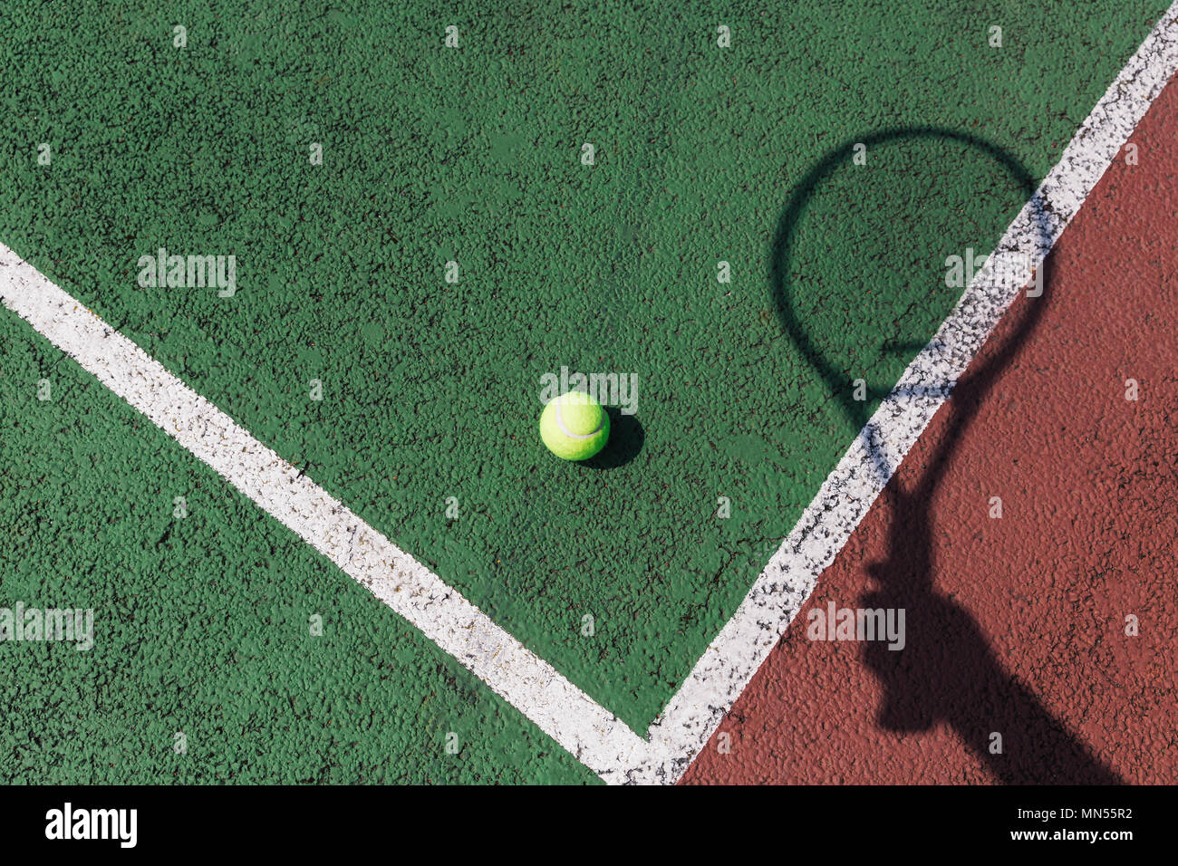 Tennisschläger Schatten und Ball auf grün Tennisplatz Stockfoto