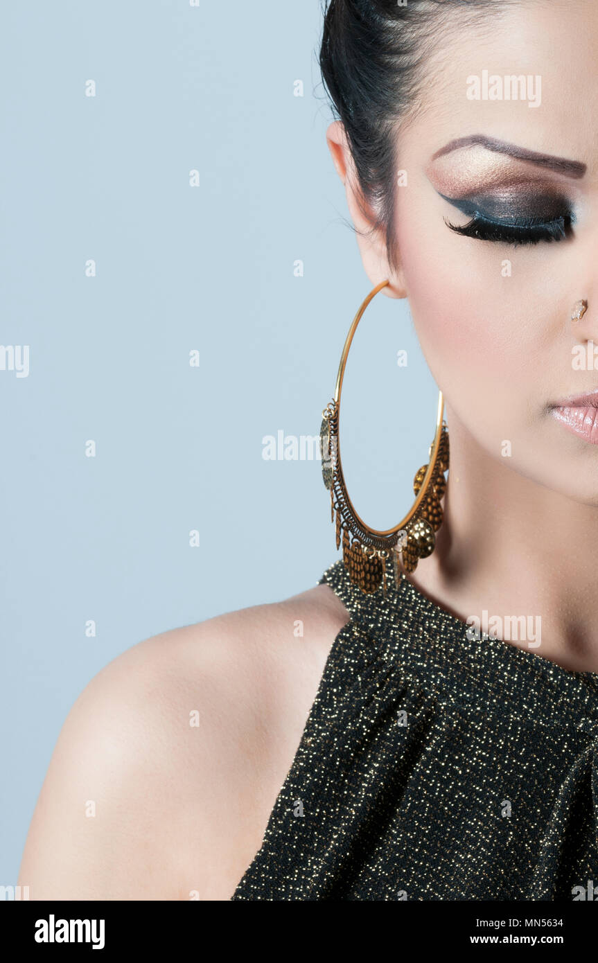 Nahaufnahme einer Frau tragen Make-up und große gold Ohrringe  Stockfotografie - Alamy