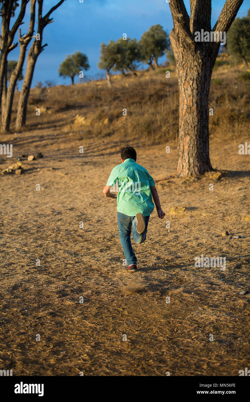 Rückansicht eines jungen entfernt im Wald laufen Stockfoto