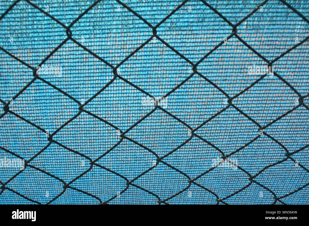 Hintergrund blaue Plane und Maschendrahtzaun Stockfoto