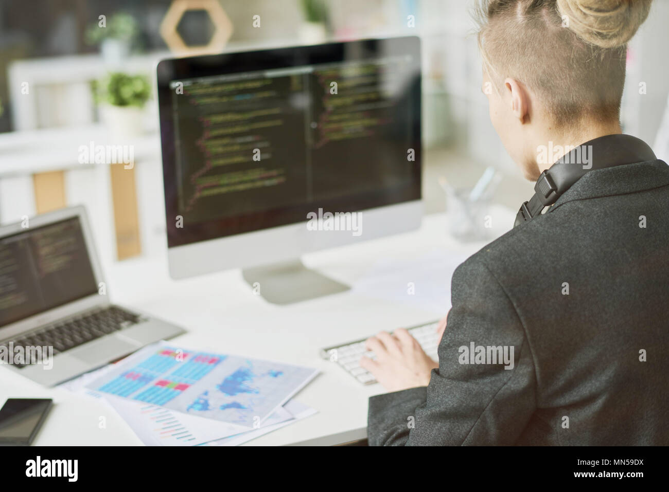 Blick über die Schulter des zeitgenössischen jungen Mann Kodierung auf modernen Computer am Schreibtisch sitzen und arbeiten in Startprojekt, Schuß aus hinter Glas Wand Stockfoto