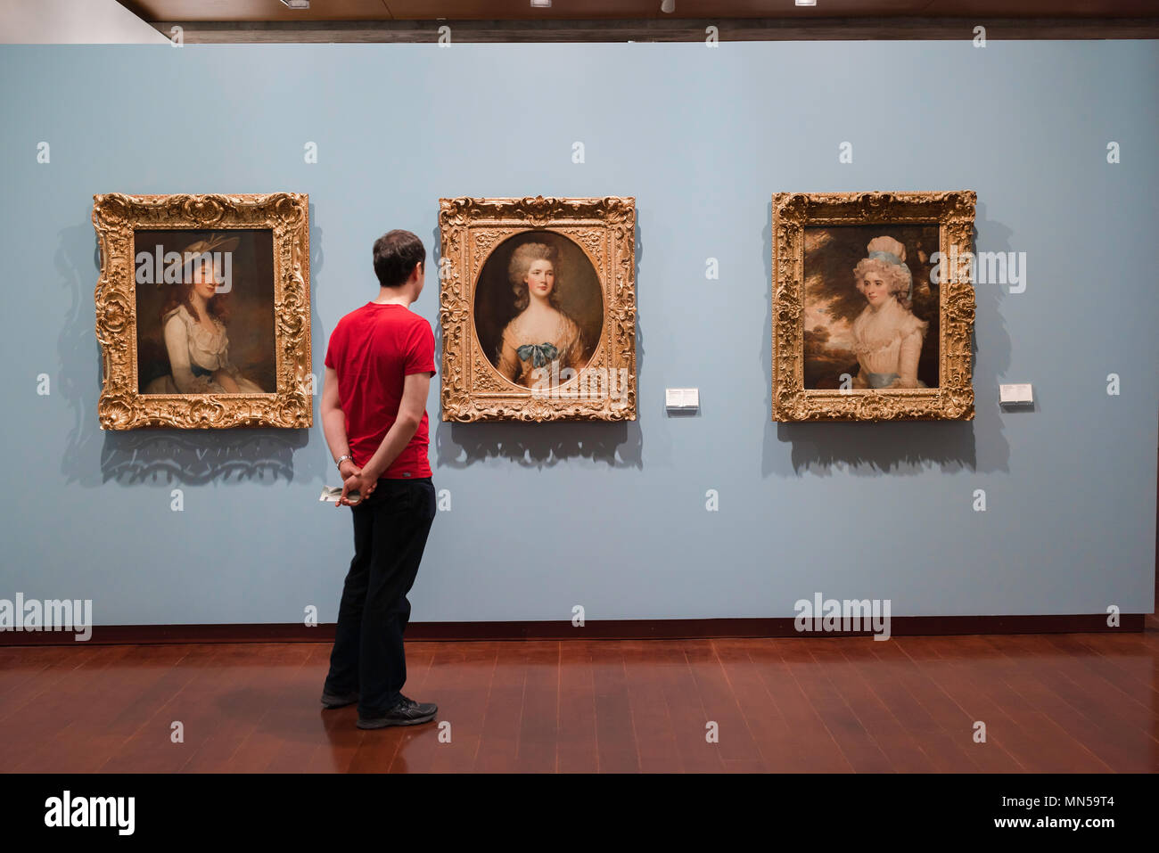 Menschenaussehende Kunst, ein Besucher des Lissabonner Museu Gulbenkian studiert drei englische Porträts aus dem 18th. Jahrhundert: (L bis R) Rowley, Gainsborough, Hoppner, Portugal Stockfoto
