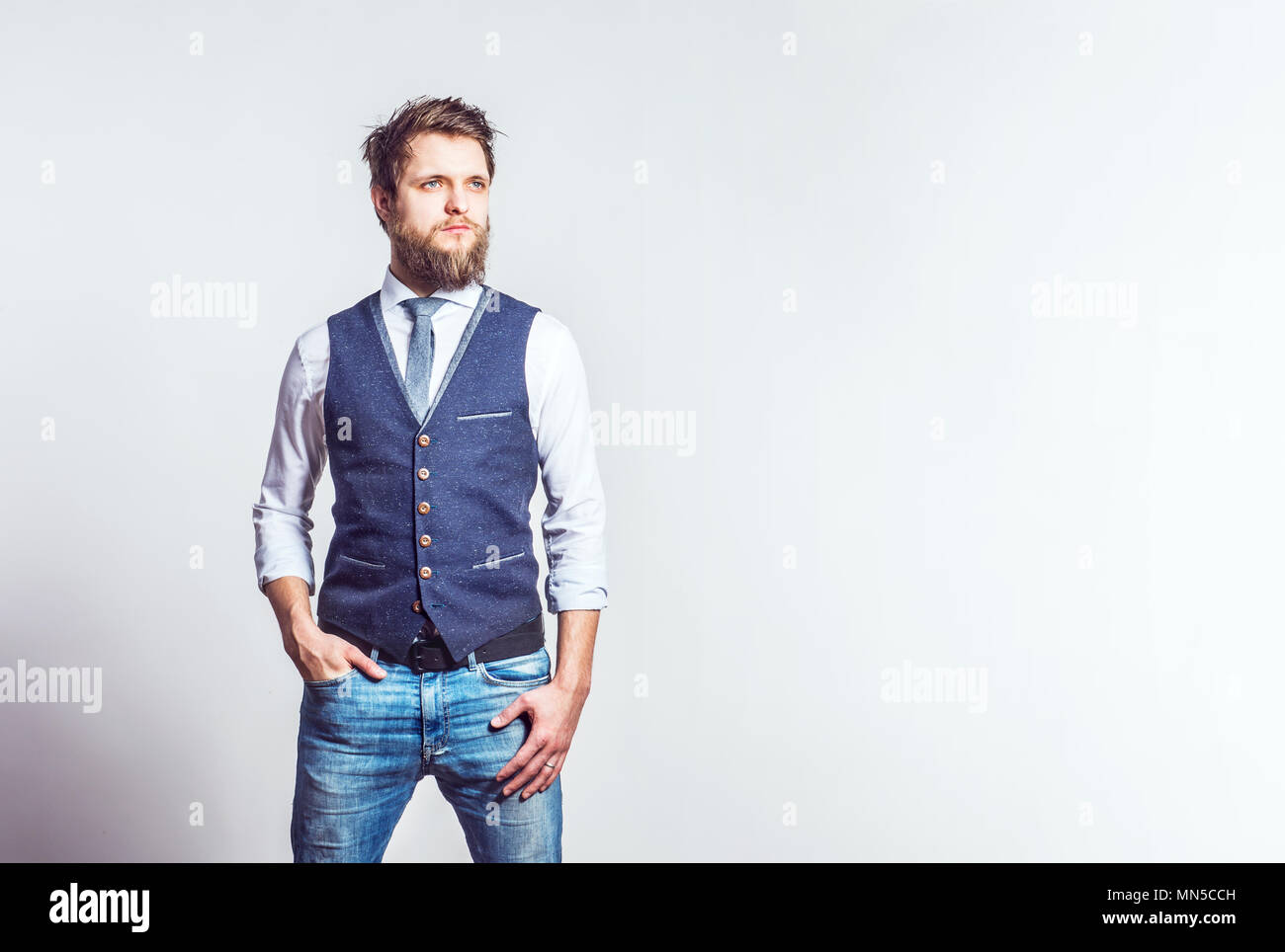 Portrait einer jungen hübschen Hippie Mann in einem Studio, Hand in der Tasche. Kopieren Sie Platz. Stockfoto