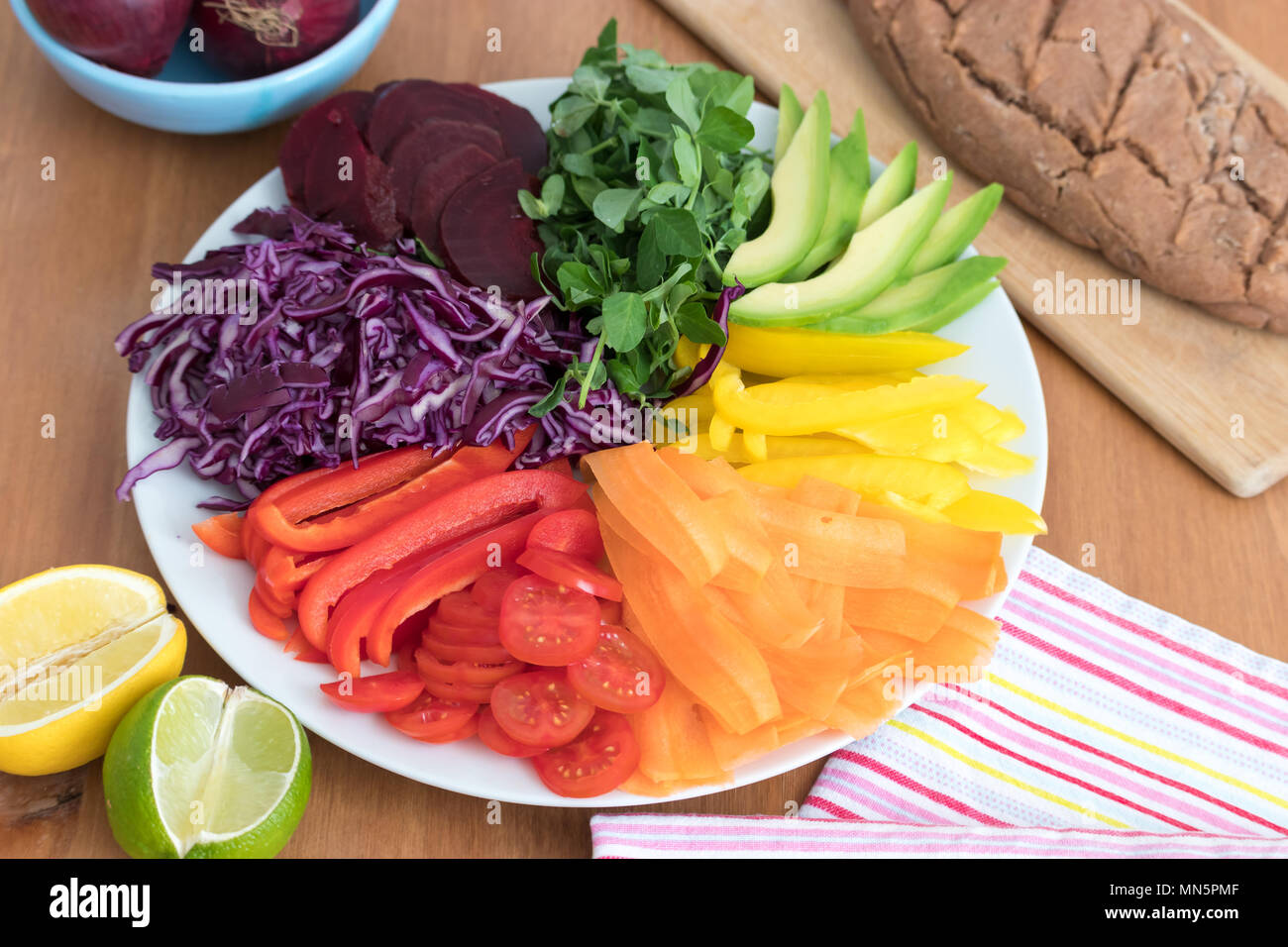 Rainbow Salat mit frischen Backwaren, glutenfrei Buchweizen Brot. Dieses gesunde Mahlzeit enthält Avocado, Paprika, Tomaten, Karotten, rote Rüben, Kohl & peashoots. Stockfoto