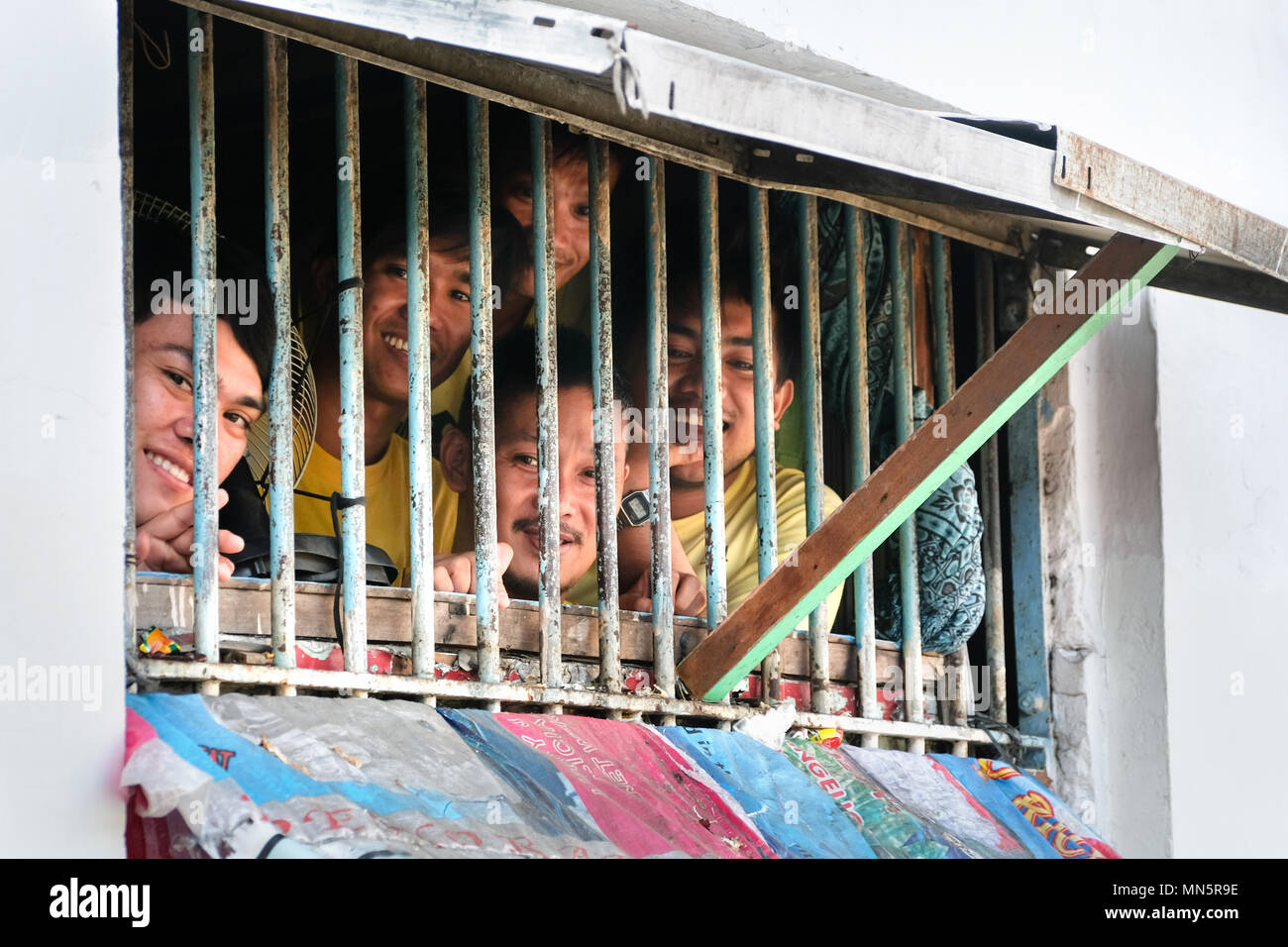 Häftlinge aus dem vergitterten Fenster in ihrer Zelle im Gefängnis in der Stadt Manila Manila, Philippinen Stockfoto