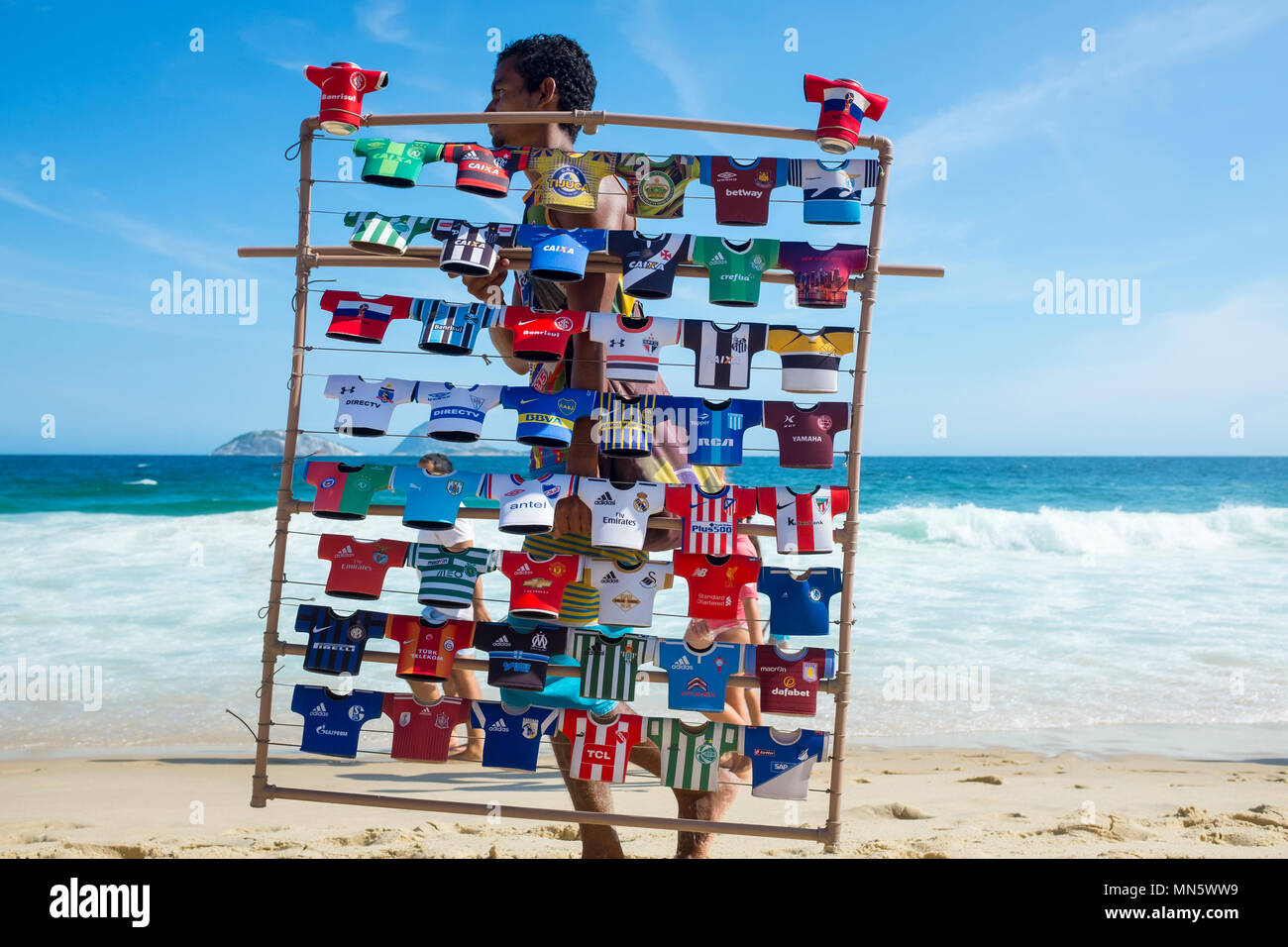 RIO DE JANEIRO - Februar 10, 2017: Ein brasilianischer Hersteller verkaufte Soccer Team Jersey souvenir trinken Kulis Spaziergänge am Strand von Ipanema mit seinem Display Rack Stockfoto