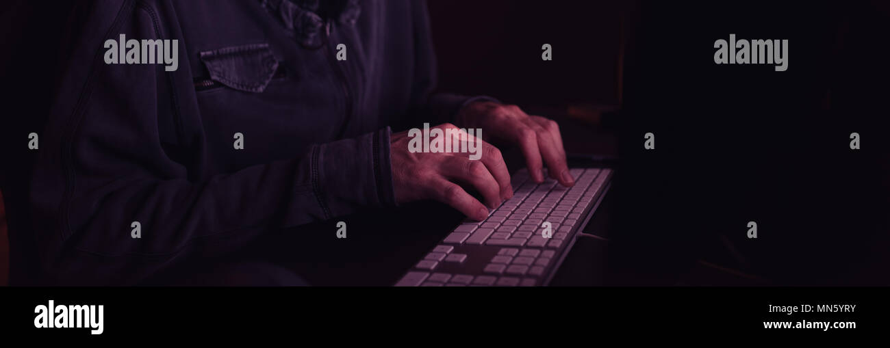 Computer hacker Eingabe Tastatur in dunklen Innenraum, Low Key mit selektiven Fokus Stockfoto