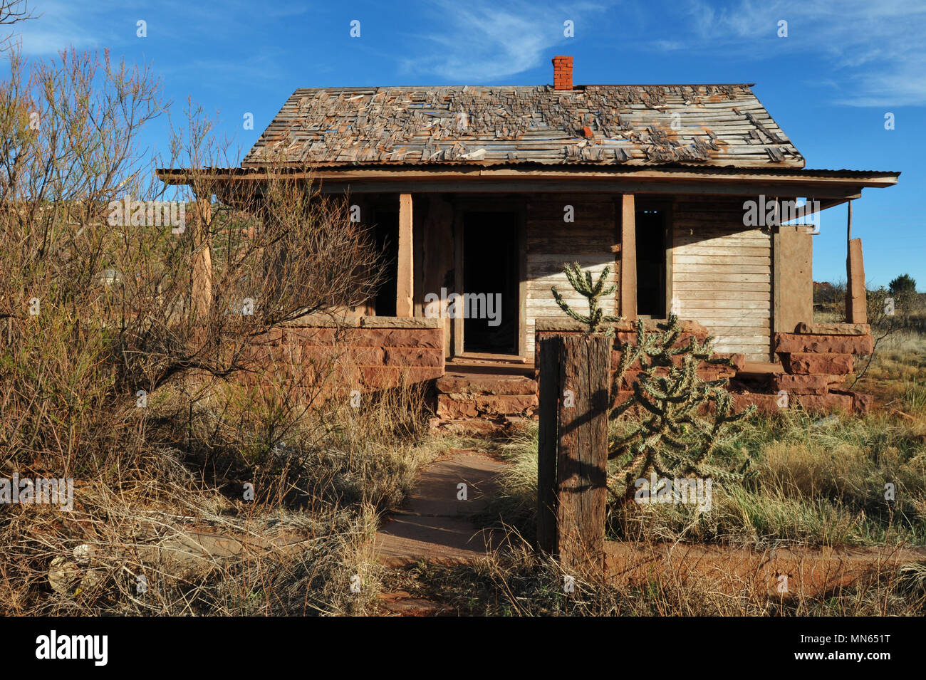 Ein verlassenes Haus auf einem bewachsenen Grundstück in der Route 66 Stadt Cuervo, New Mexiko. Stockfoto