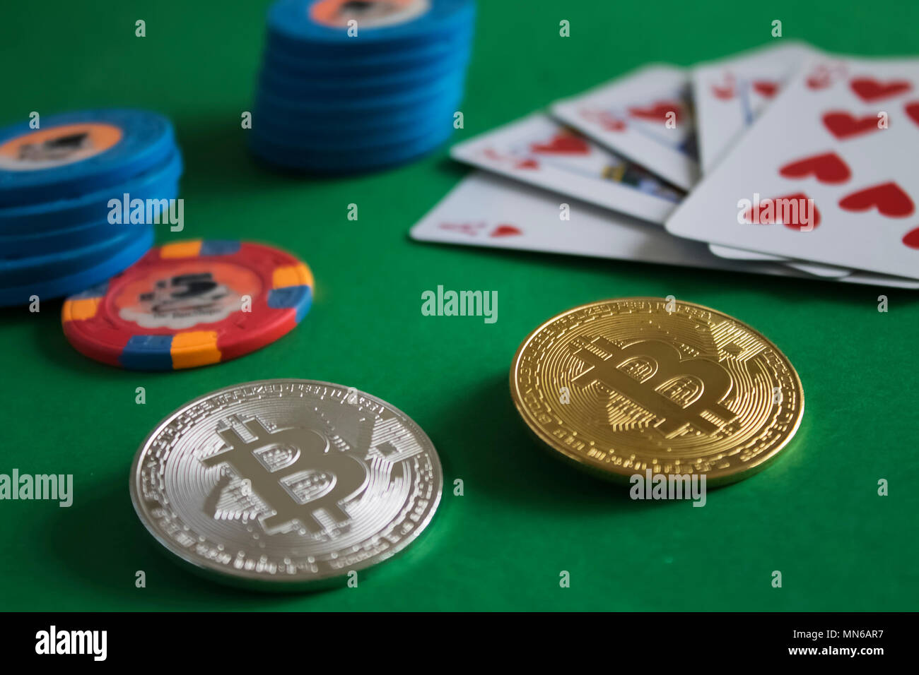 Zwei bitcoins zur Festlegung auf grün Pokertisch und Haufen von Chips mit Karten im Hintergrund | Gold | Silber | blau | Spülen Stockfoto