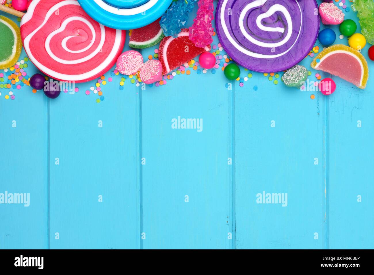 Obere Grenze von verschiedenen bunten Bonbons vor blauem Holz Hintergrund Stockfoto