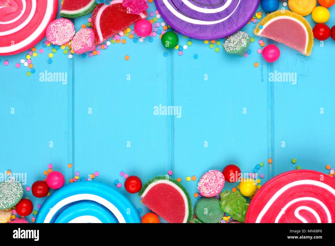 Doppelte Grenze der sortierten Bunte Bonbons vor blauem Holz Hintergrund Stockfoto