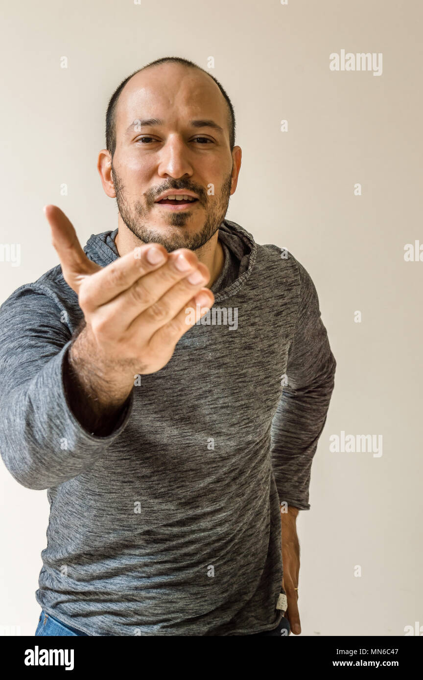 Junger Mann zeigende Hand Gruß die Kamera auf klaren Hintergrund isoliert Stockfoto