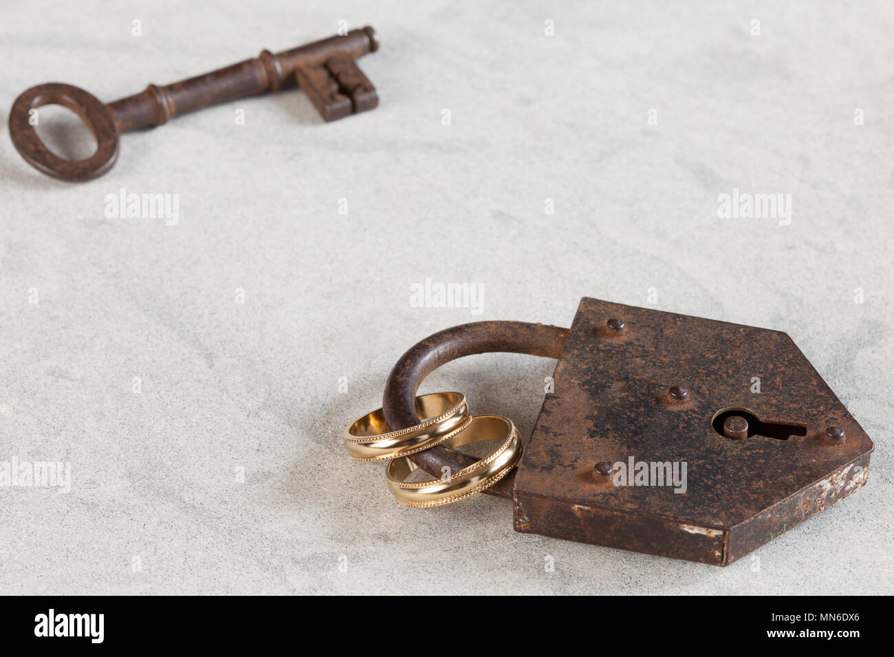 Hochzeit Ringe durch ein rostiges Lock gebunden Stockfoto