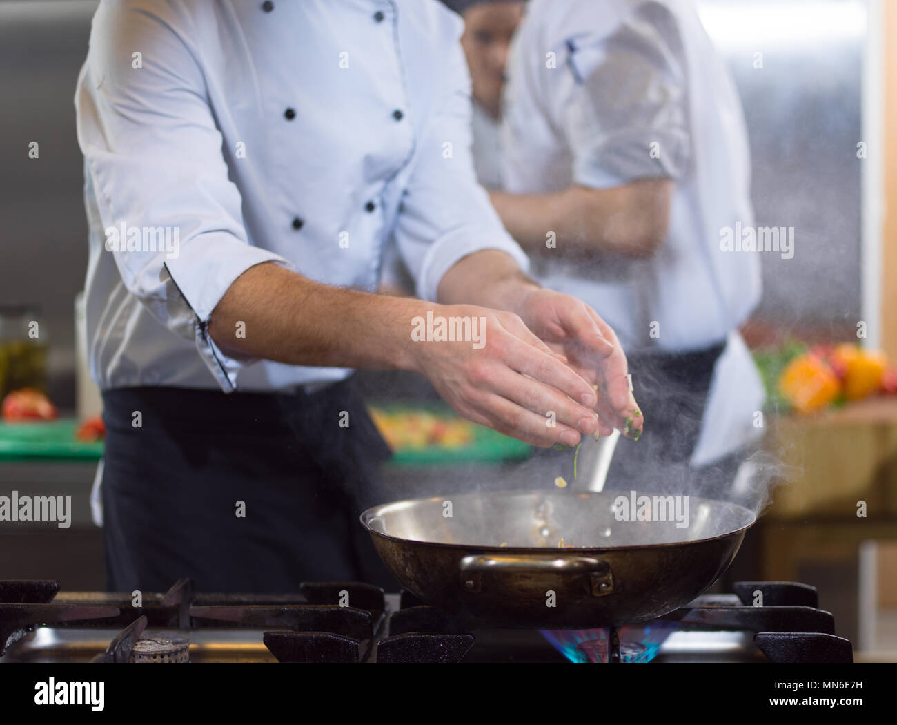 Chefkoch Kochen, Braten im Wok Pfanne. Verkauf und Essen Konzept Stockfoto