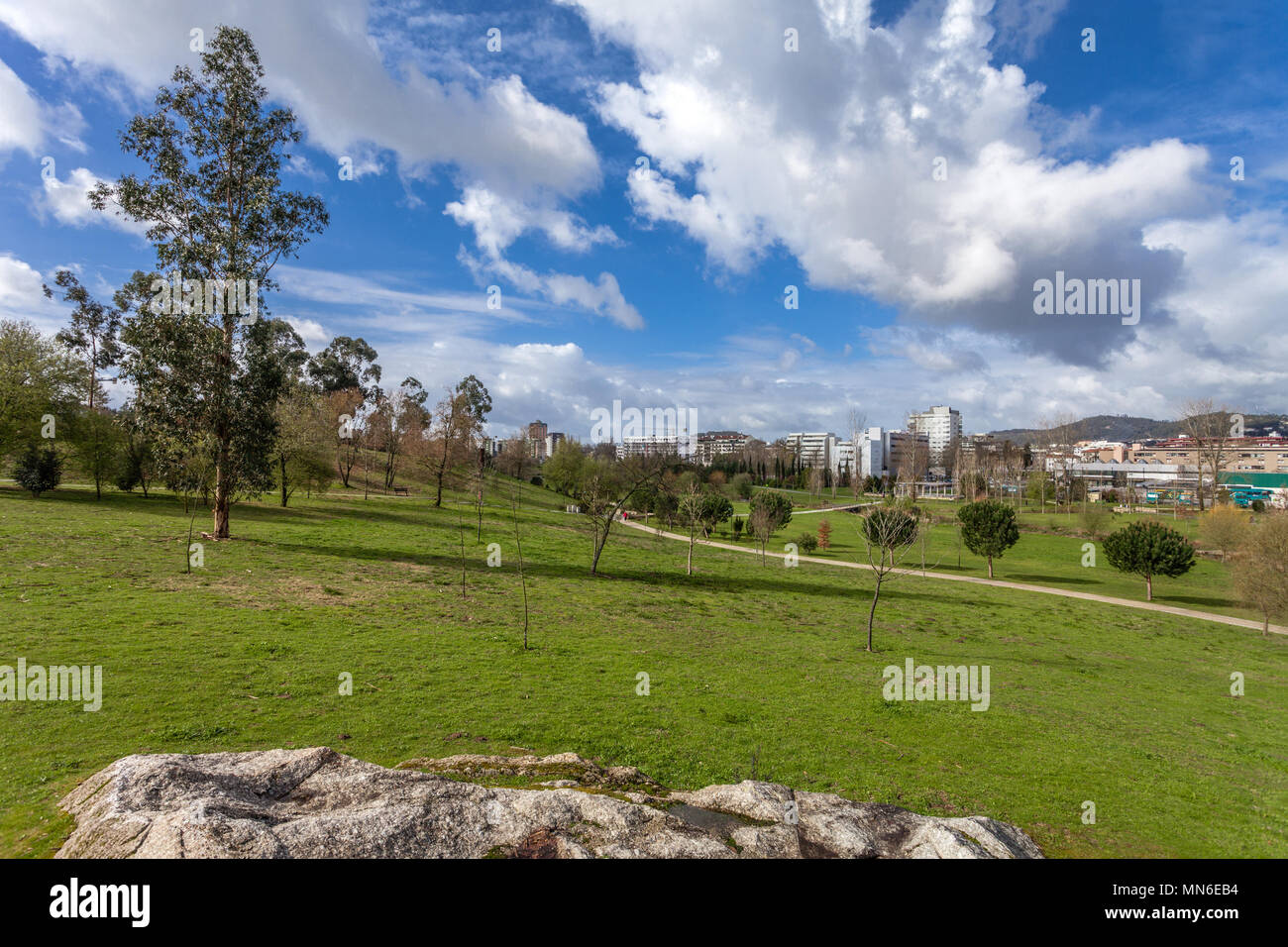 Großen, leeren grünen Rasen, mit Blick auf die Stadt im Parque da Devesa städtischen Park. Blauer Himmel, große weiße Wolken. Vila Nova de Famalicao, Portugal Stockfoto