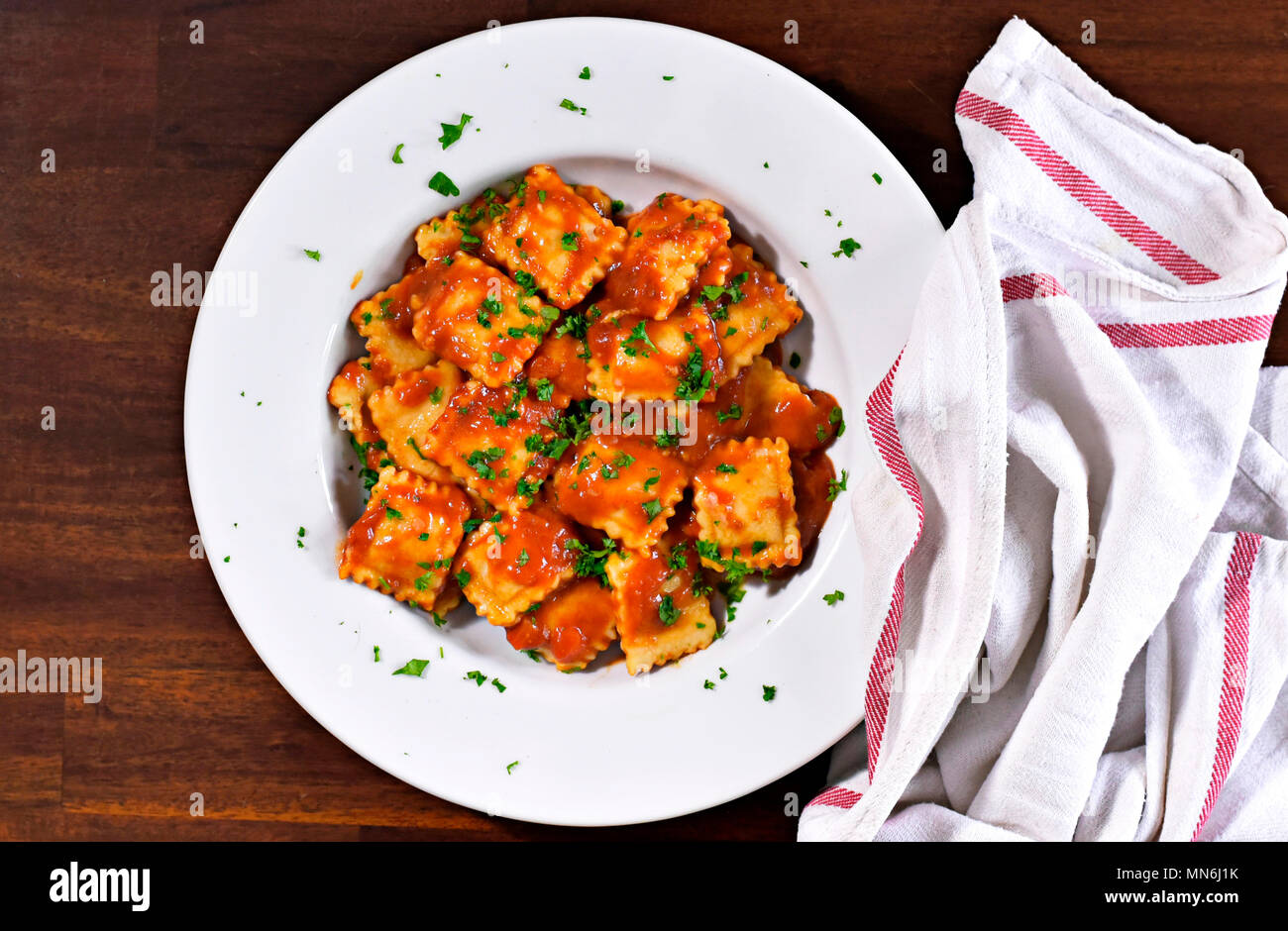 Frische ravioli Pasta mit Petersilie und Basilikum Blätter, italienische Küche. Weiße Platte und Holztisch, Pasta. Stockfoto