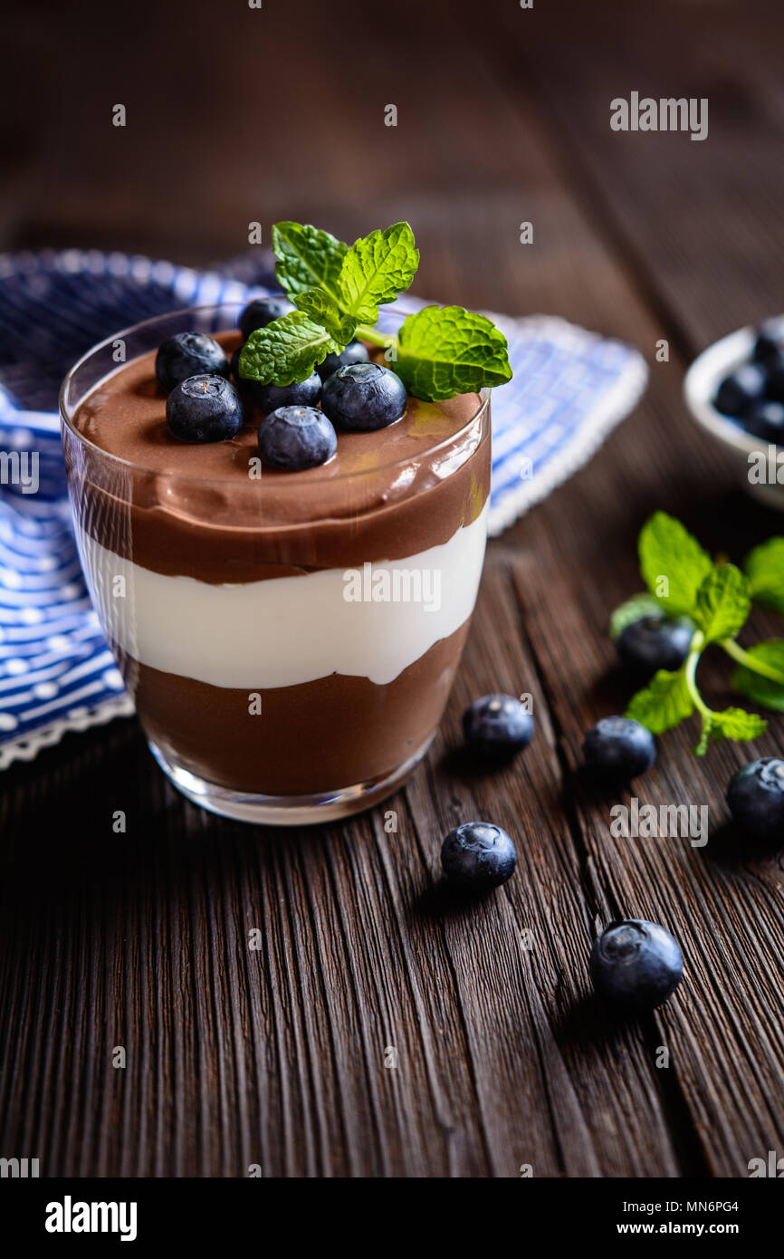 2-in-1-Schokolade und Vanille mascarpone Nachtisch gekrönt mit Blaubeere, im Glas serviert. Stockfoto
