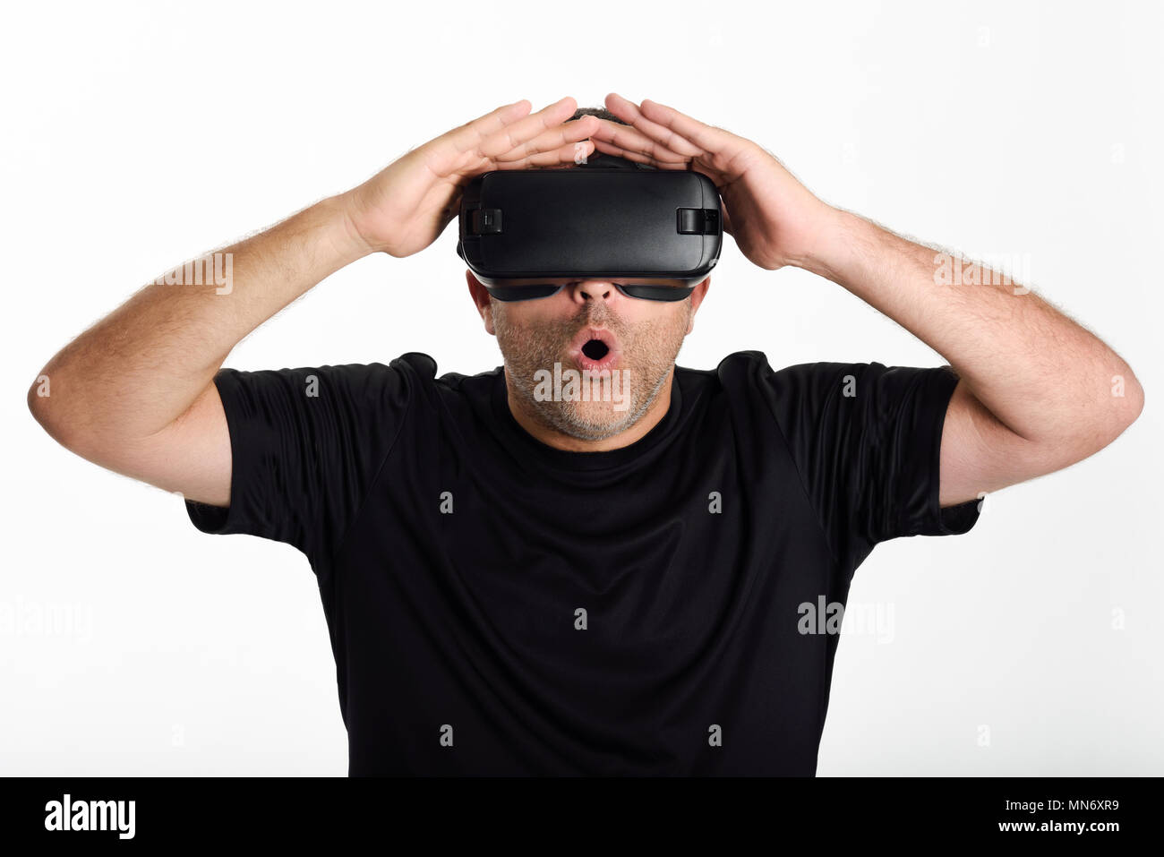 Mann, im VR-Brille und gestikulierte wild mit seinen Händen. Schön überrascht Kerl mit Virtual reality Brillen Filme anschauen oder Videospiele spielen, auf weißem Hintergrund. Stockfoto