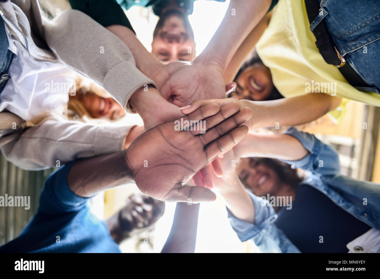 Nahaufnahme der jungen Menschen die Hände zusammen. Freunde mit Stack der Hände, die Einheit und Zusammenarbeit. Stockfoto