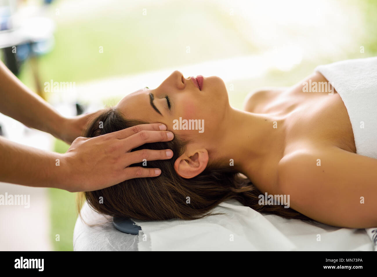 Junge kaukasier lächelnde Frau mit einem Kopf Massage im Spa Center mit geschlossenen Augen. Weibliche Patienten ist, die Behandlung von professionellen Therapeuten. Stockfoto