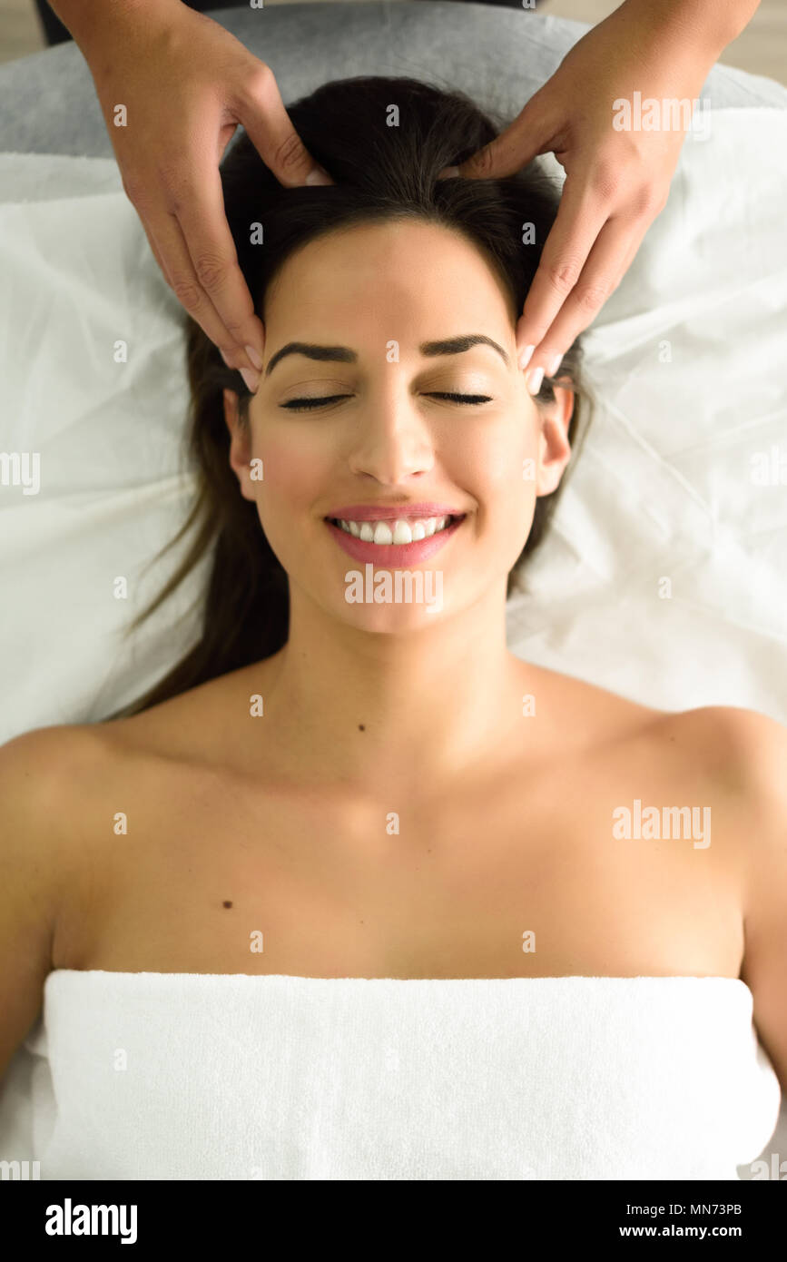 Blick von oben auf die jungen kaukasischen lächelnde Frau mit einem Kopf Massage im Spa Center mit geschlossenen Augen. Weibliche Patienten ist, die Behandlung von professionellen Therapeuten. Stockfoto