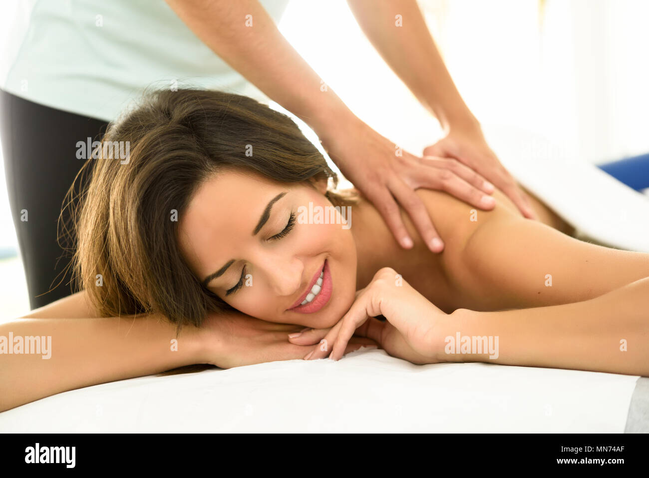 Junge Frauen, die eine Rückenmassage in einem Wellnesscenter. Weibliche Patienten ist, die Behandlung von professionellen Therapeuten. Stockfoto