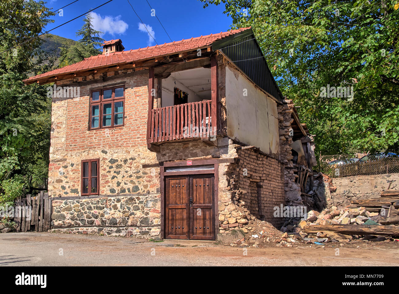 Alte beschädigt traditionellen Haus aus Stein Gebäude mit Balkon in Republik Vevčani, DER EHEMALIGEN JUGOSLAWISCHEN REPUBLIK MAZEDONIEN Mazedonien, Balkan Stockfoto