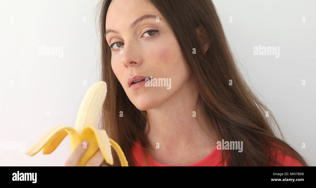 Attraktive Frau schälen und Essen eine Big Banana Stockfoto