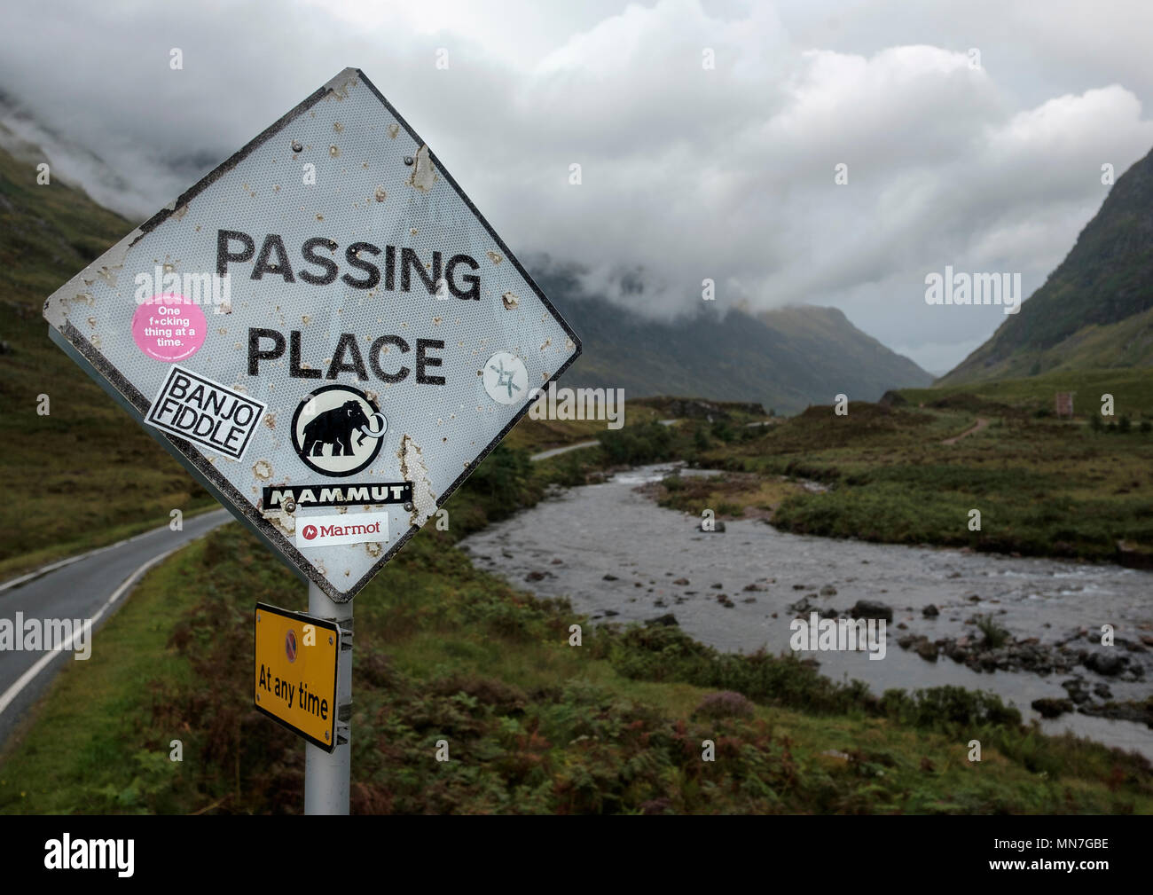 Eine Weitergabe Ort Schild in einer einzigen Straße neben dem Fluss Coe im Glen Coe unkenntlich mit Aufkleber Stockfoto