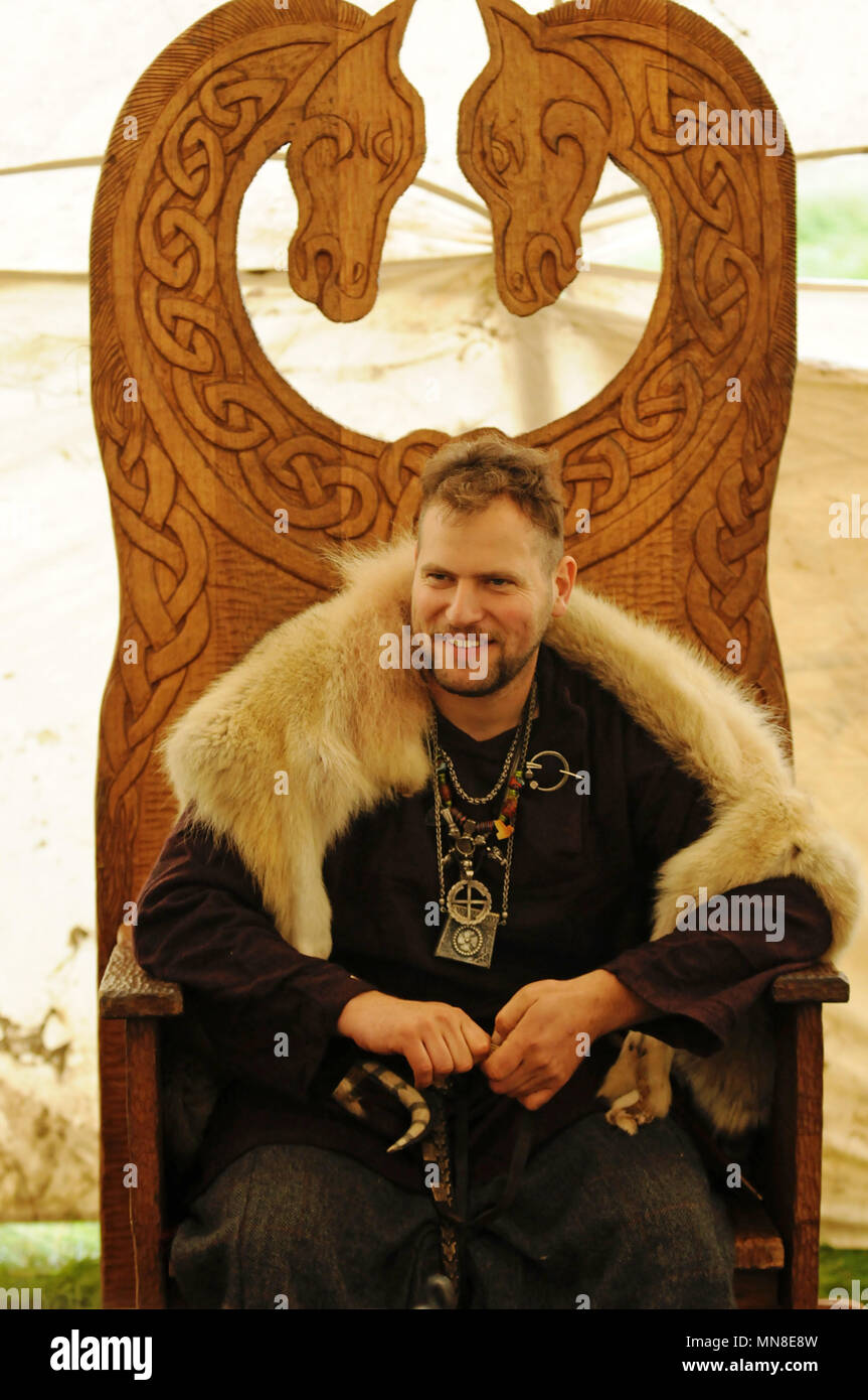 Viking saß in reich verzierten hölzernen Stuhl tragen tierischer Haut Stockfoto