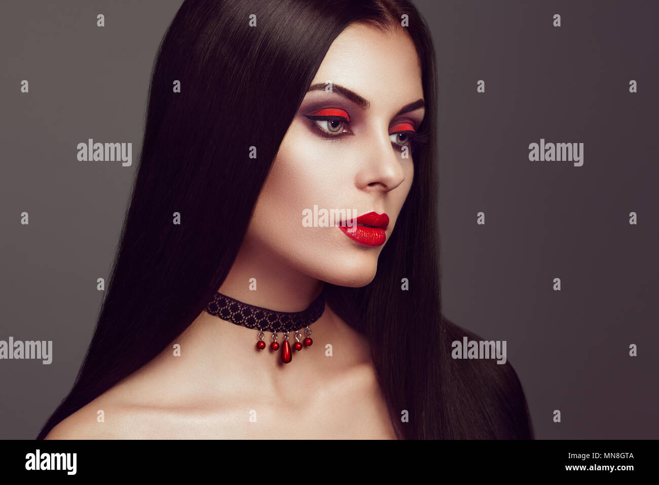 Halloween Vampir Frau Porträt. Schöne Glamour Fashion Sexy Vampir Frau mit langen dunklen Haare, Beauty Make Up und Kostüme Stockfoto