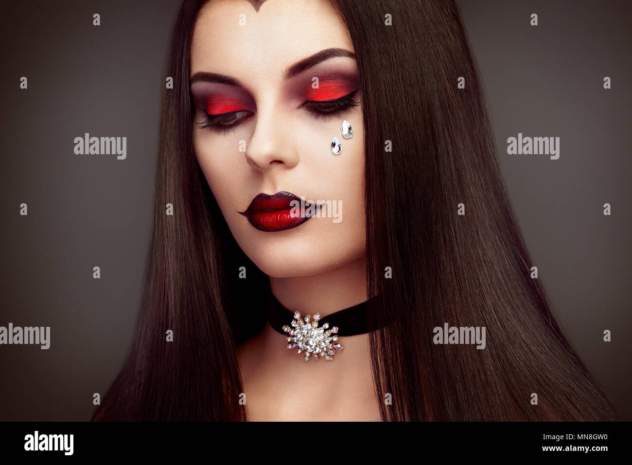 Halloween Vampir Frau Porträt. Schöne Glamour Fashion Sexy Vampir Frau mit langen dunklen Haare, Beauty Make up und Kostüme Stockfoto