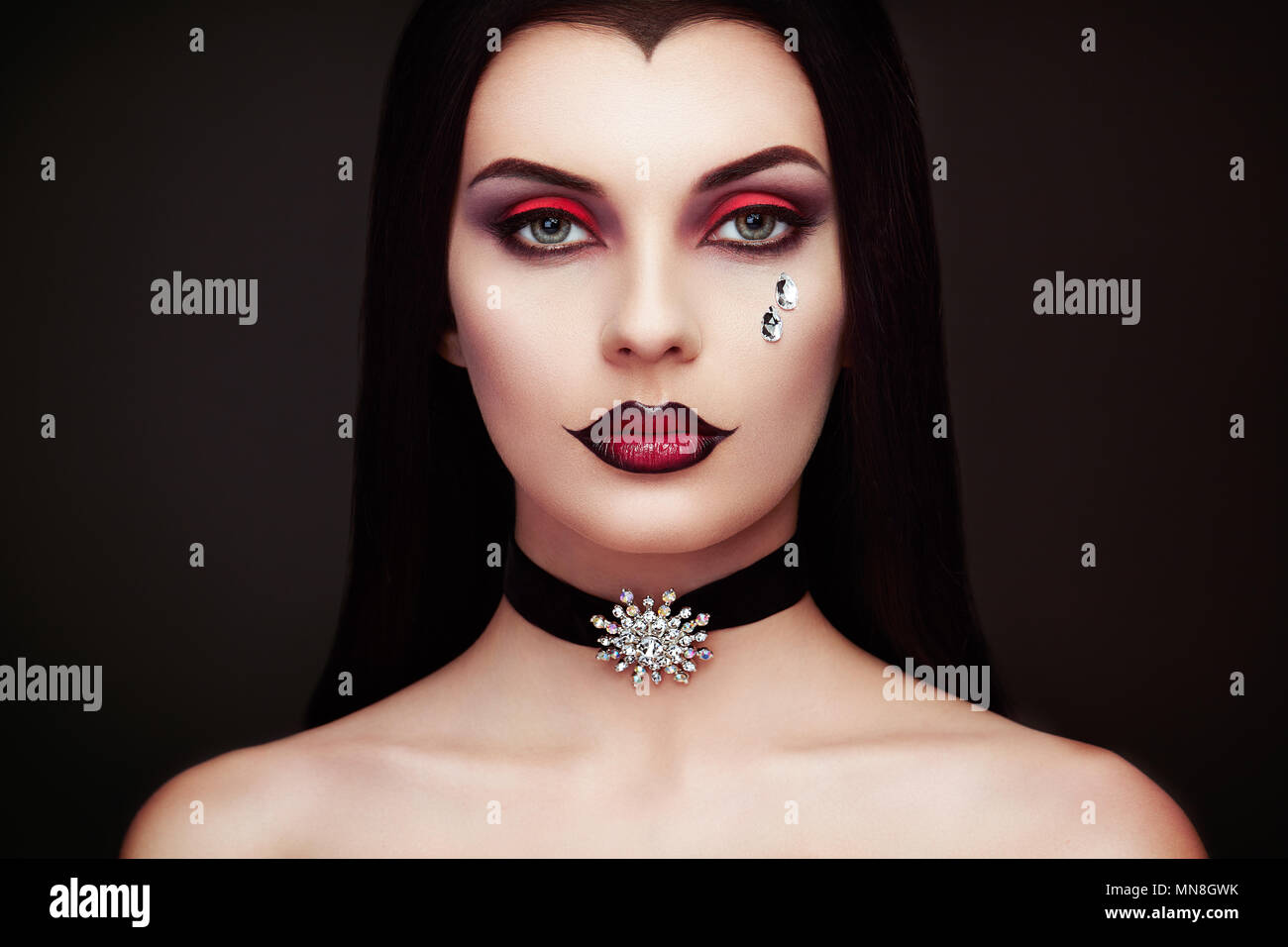 Halloween Vampir Frau Porträt. Schöne Glamour Fashion Sexy Vampir Frau mit langen dunklen Haare, Beauty Make up und Kostüme Stockfoto