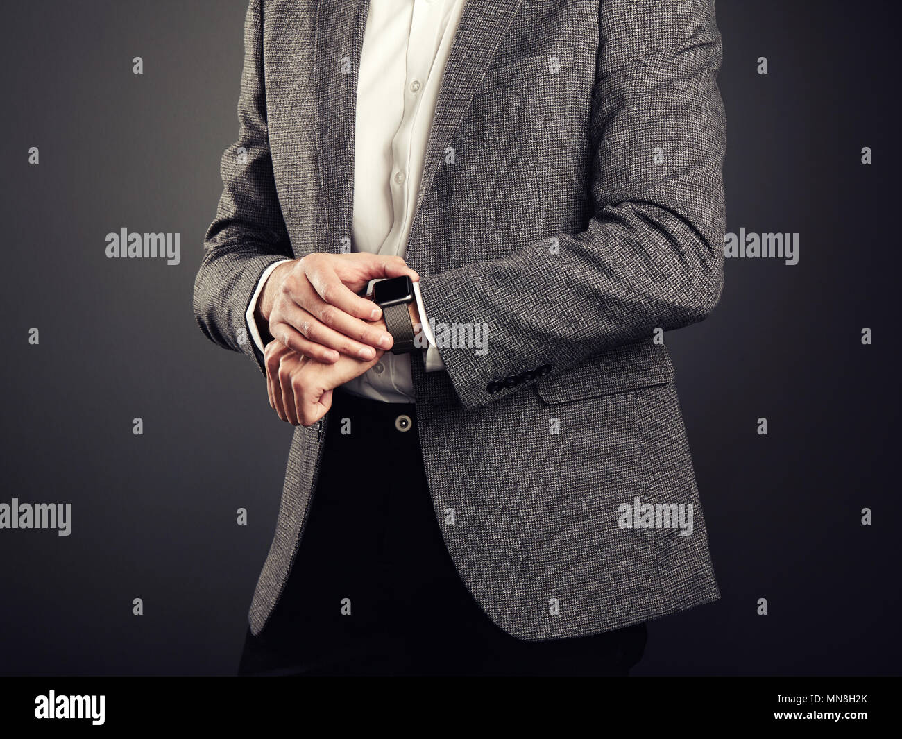 Hübscher junger Mann in Anzug. Lässigen Stil und elektronische Geräte. Smart Watch, Business Stil Stockfoto