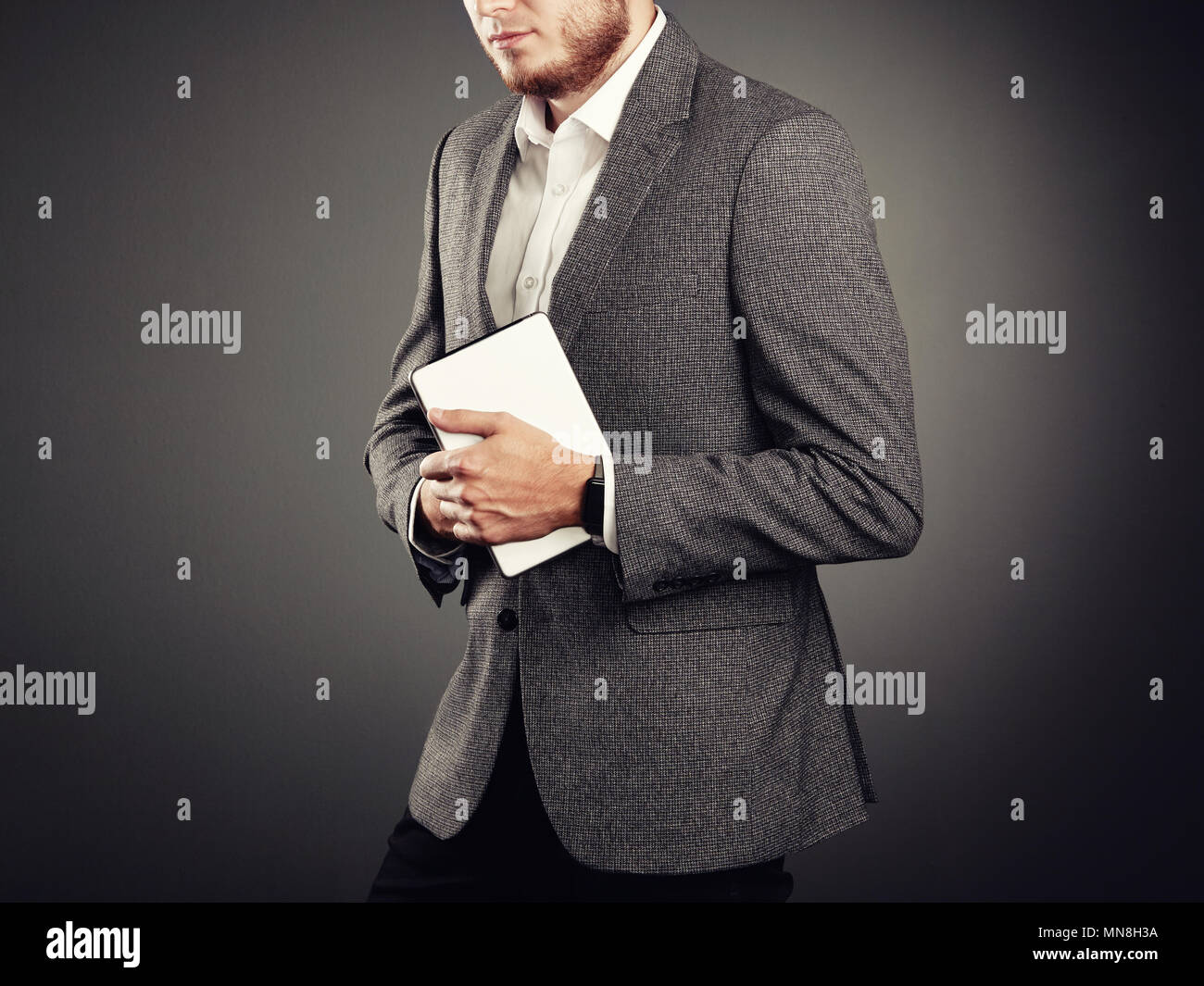 Hübscher junger Mann in Anzug. Lässigen Stil und elektronische Geräte. Smart Uhren und Digitale Tablet Stockfoto