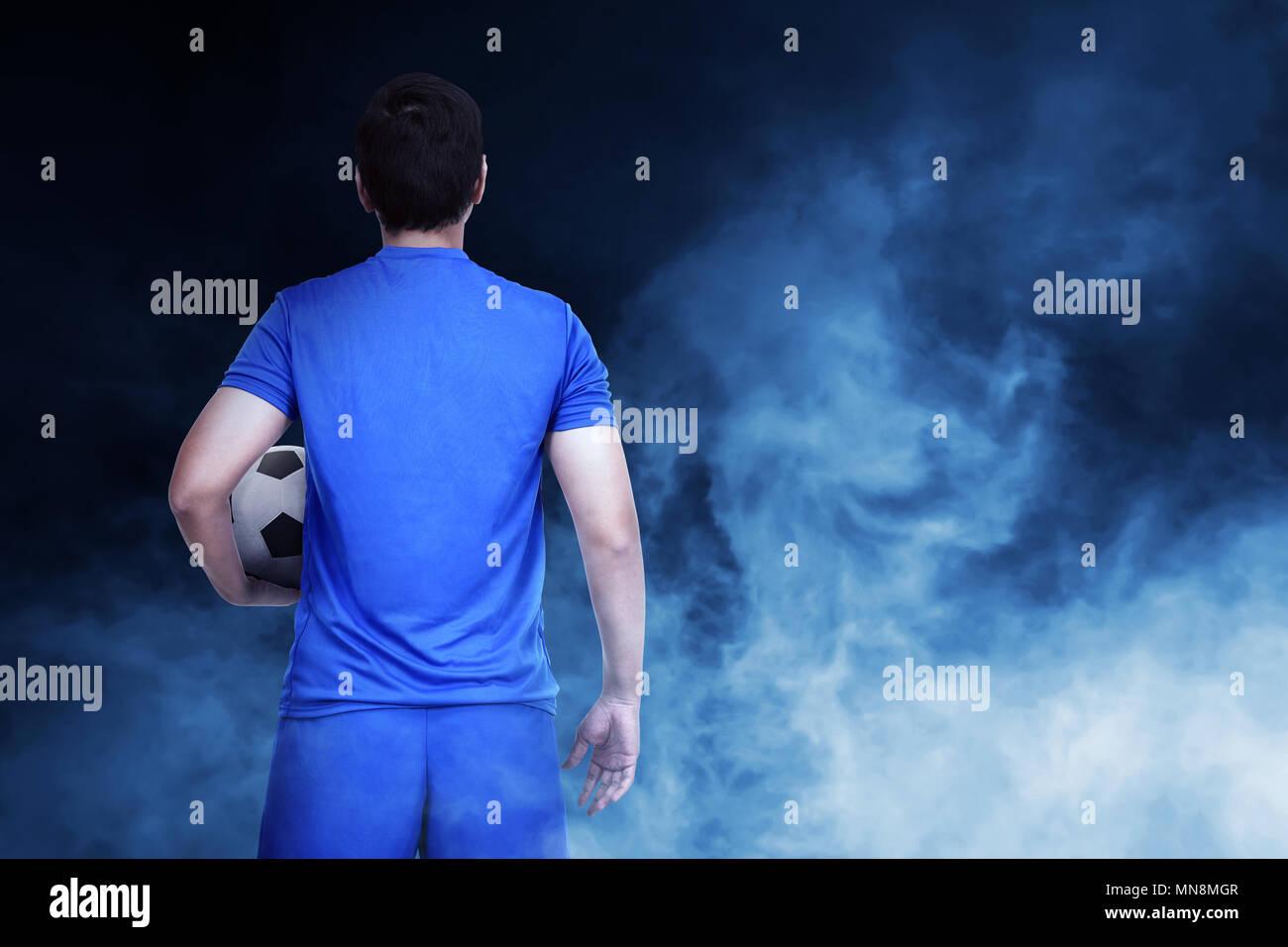 Junge asiatische Fußballspieler mit der Kugel auf abstrakten Hintergrund Stockfoto