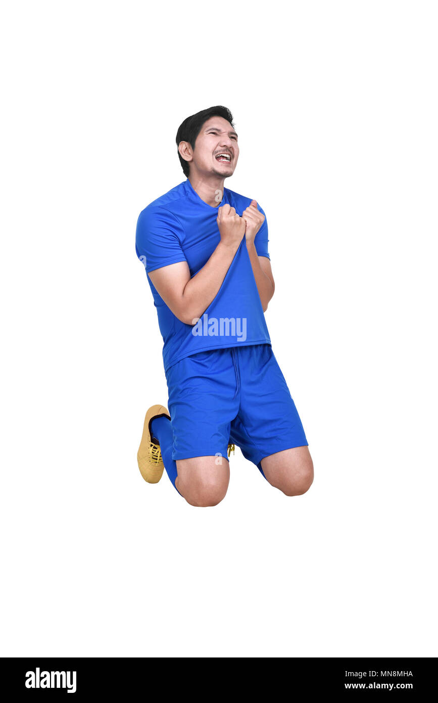Professionelle asian football player mit blauen Jersey feiert über weißem Hintergrund Stockfoto