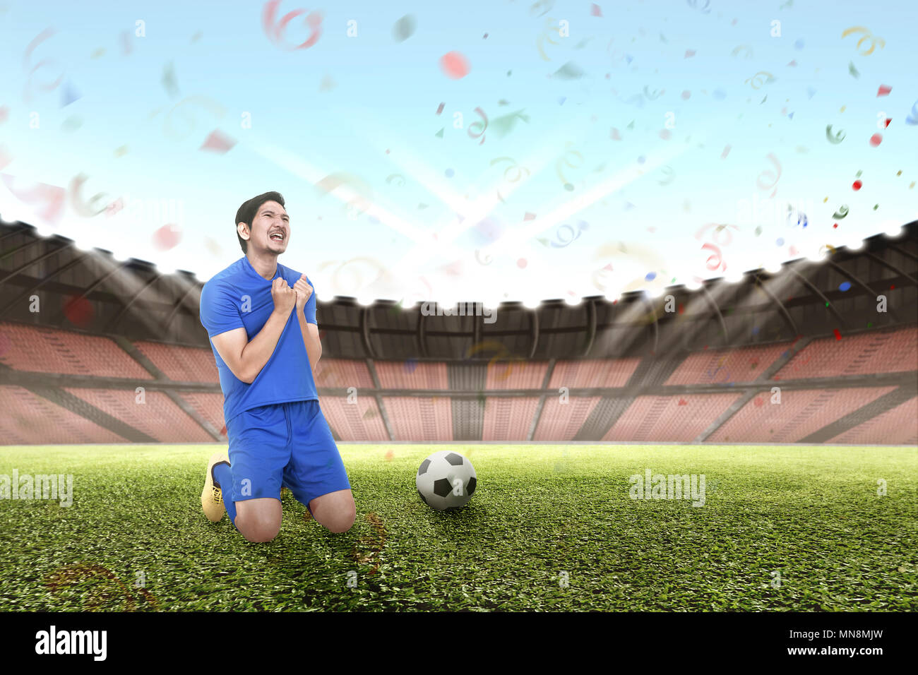 Freundliche asiatische Fußballer feiern Sieg im Stadion Stockfoto