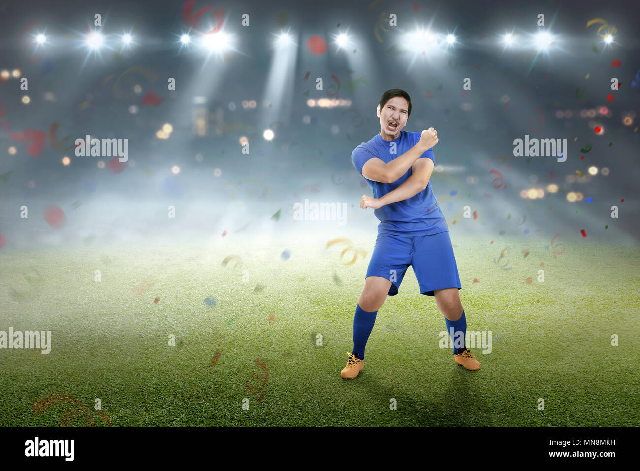 Expressive asiatische Fußballspieler nach dem Gewinn des Spiels auf dem Feld Stockfoto