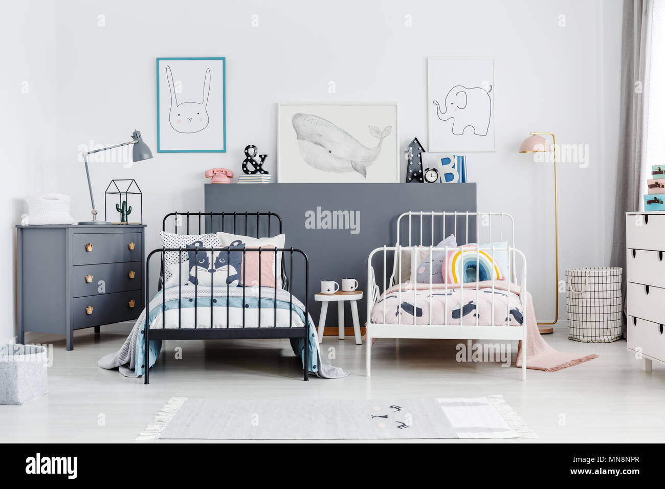 Schwarz und Weiß Betten in bunten Kinder Schlafzimmer Innenraum mit Poster und Lampe im Schrank. Real Photo Stockfoto
