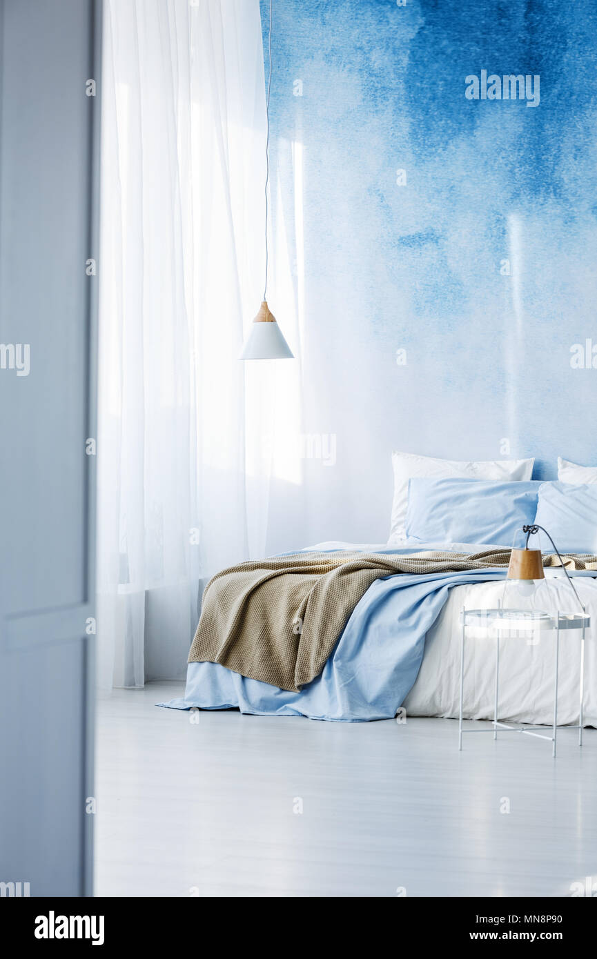 Helles Schlafzimmer mit Doppelbett, beige Decke und ombre Wand Stockfoto