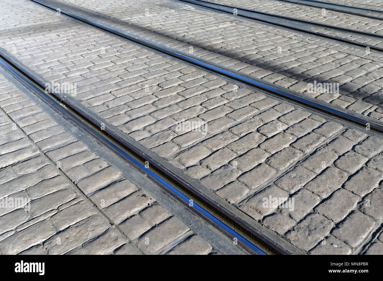 Neben Spießrutenlauf tram Tracks auf einer gepflasterten Straße. Stockfoto