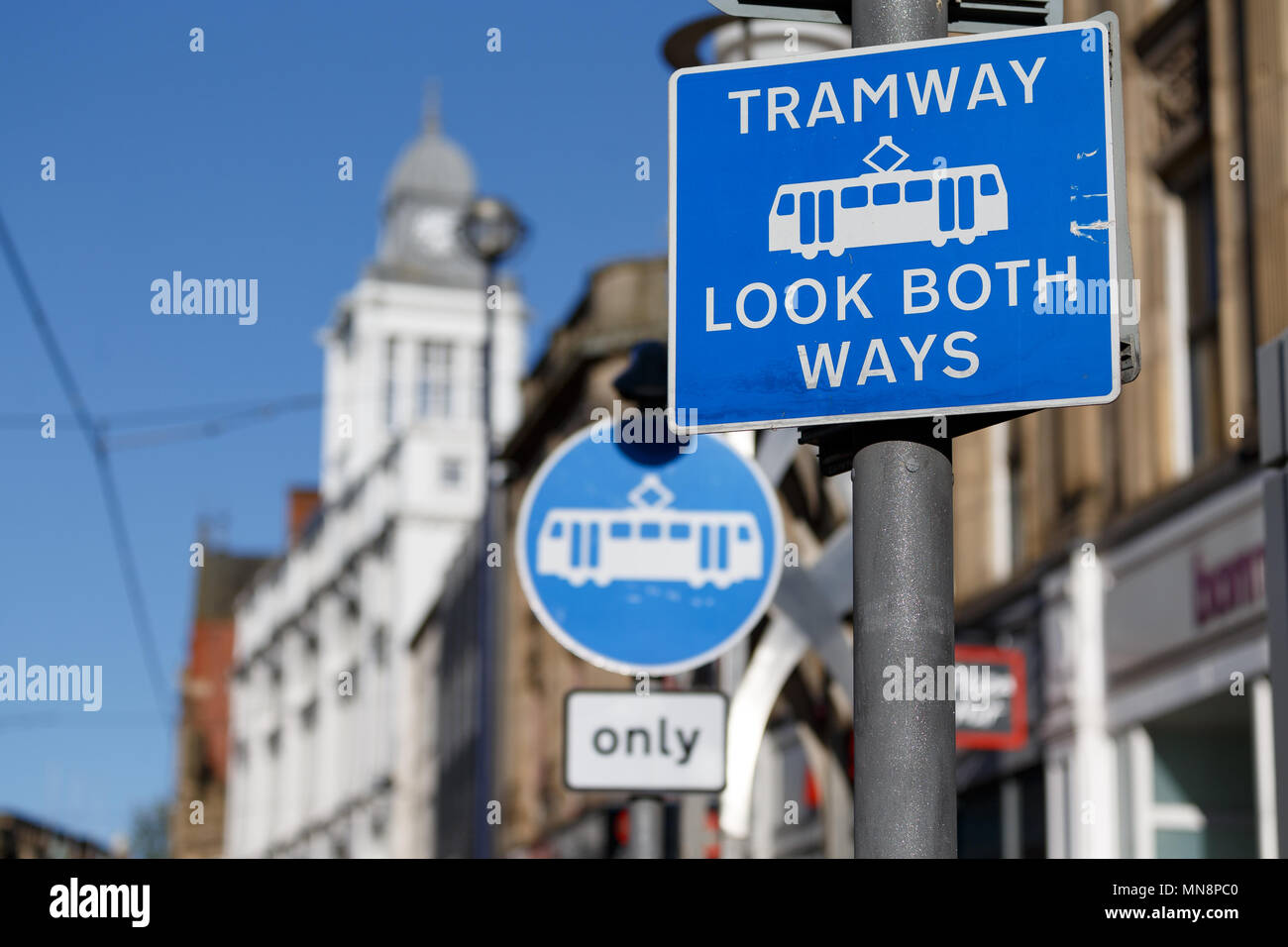 Ein UK street sign Warnung von Fußgängern Straßenbahn, schauen beide Wege "In einer Straßenbahn Kreuzung in Sheffield. Hinter ist ein Zeichen Warnung Autofahrer Straßenbahnen nur'. Stockfoto