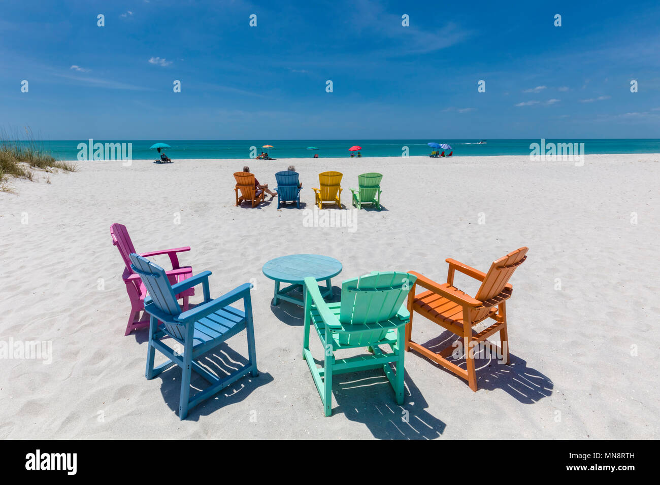 Bunte Stühle auf den Golf von Mexiko Strand am South Beach Bar & Grill in Boca Grande am Gasparilla Island, Florida Stockfoto