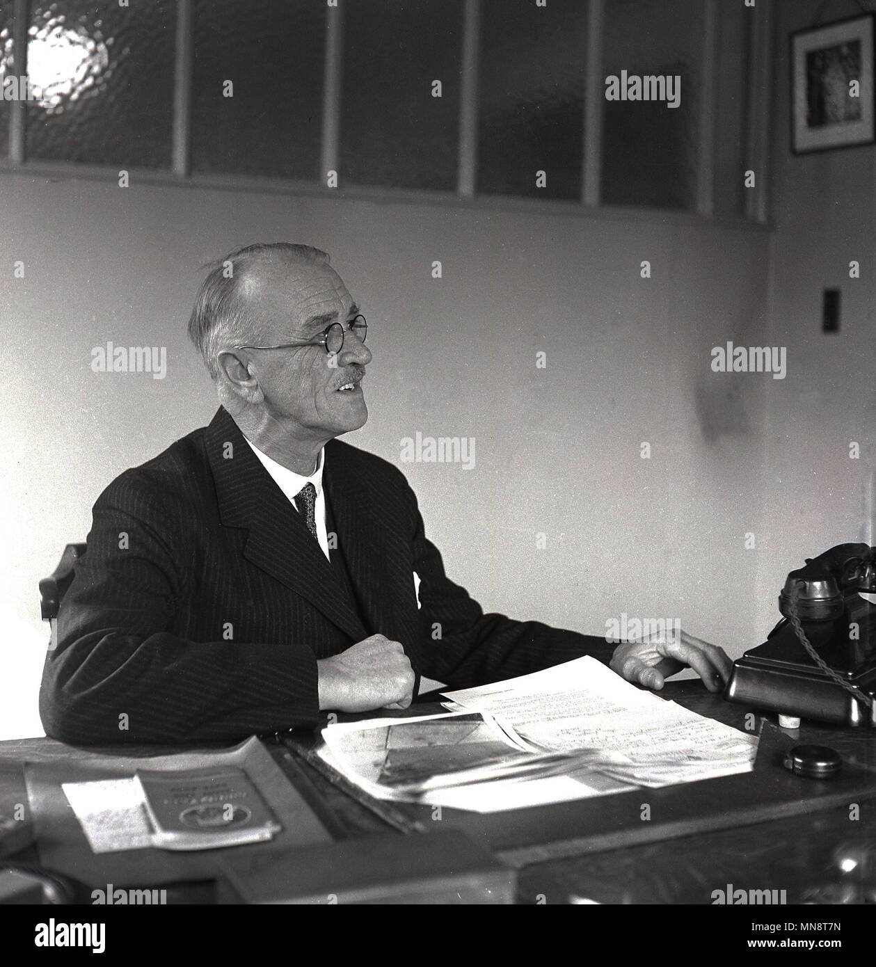 1950, historische Bild eines älteren Geschäftsführer des Reifens business, ATS, Reifenservice, in seinem Büro, England, UK. Stockfoto